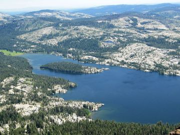 A scenic mountain lake surrounded by rocky terrain and forest.