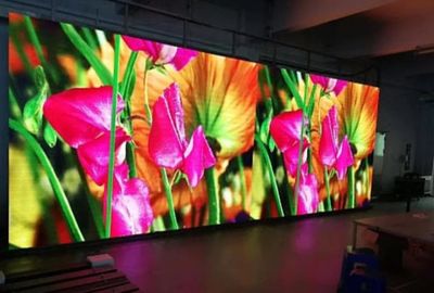 A vibrant LED screen displays colorful flowers indoors.