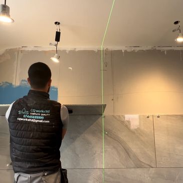 cq works ltd laying a large format gloss grey tile onto a wall