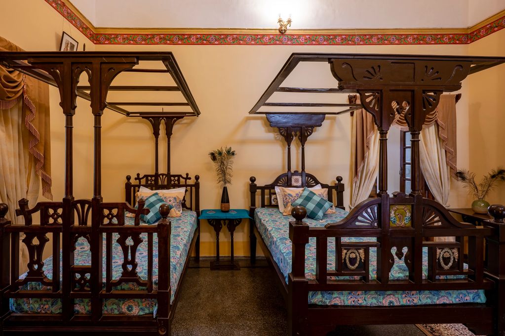 The Raja Sahib's room, rare Tukdi work floor and Burma Teakwood bed and a functional fireplace. 