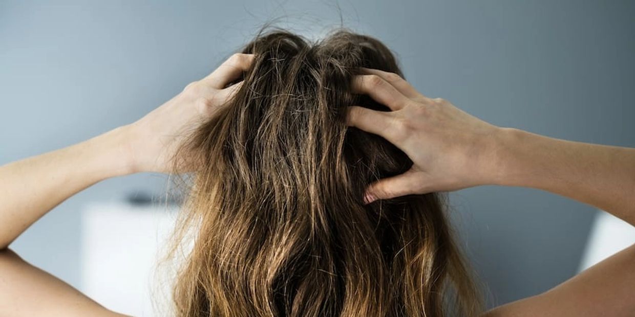 Lady grabbing her oily hair needing hairgenix hair growth gummies 