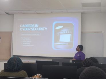 A person presenting a cybersecurity careers slide to an audience in a classroom.