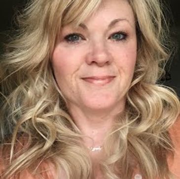 Smiling woman with long curly blonde hair and blue eyes.