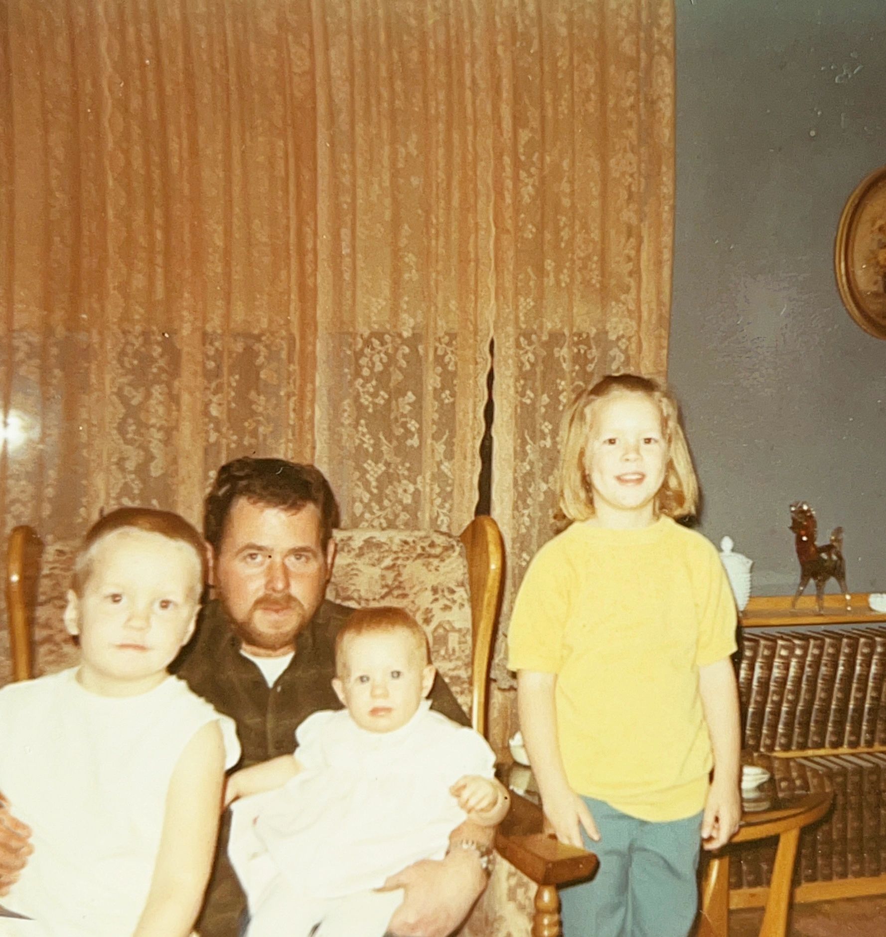 Family portrait in a vintage living room with four people.