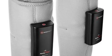 Pair of gray heated leg wraps with black control units attached.