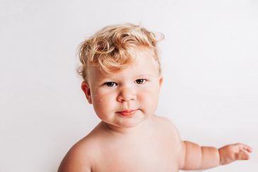 1 year old with cake on his face during a Cake Smash portrait session with Sunshine studios NZ welli