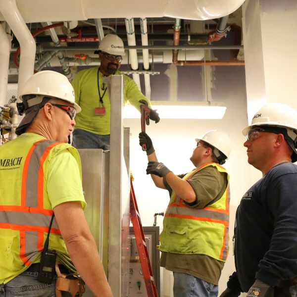 Construction workers collaborating on an industrial project indoors.