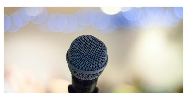Close-up of a microphone with blurred colorful lights in the background.