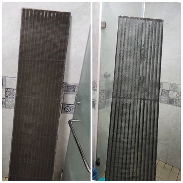 Two vertical metal mesh panels leaning against tiled walls in a bathroom.