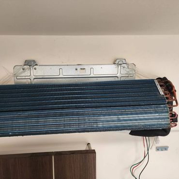 Indoor air conditioner evaporator coil mounted on wall.