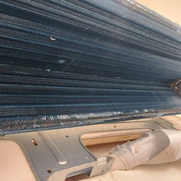 Close-up of a dusty air conditioner coil needing cleaning.