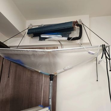 A device captures water from an air conditioner drip in a corner.