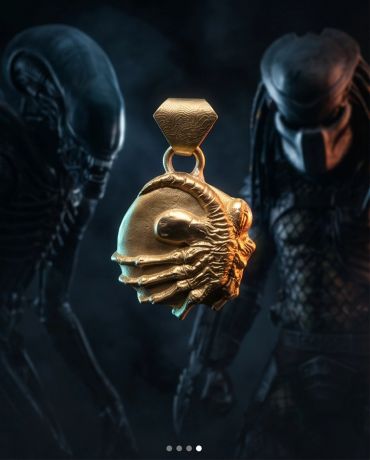 Golden alien-themed pendant with two aliens in the background.