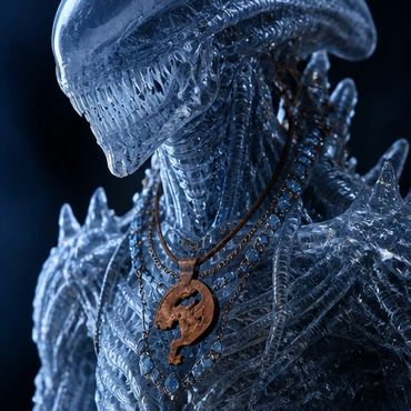 Close-up of a translucent alien figure wearing a pendant.