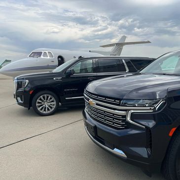 Black SUVs parked near a private jet on a tarmac.