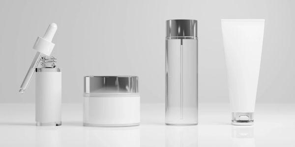 Set of four empty cosmetic containers in white with silver lids.