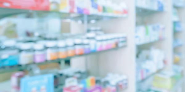 Blurred image of shelves stocked with various bottles and boxes.