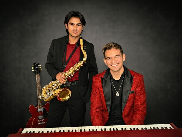 Live music duo with saxophone and piano at School of Talent in Kissimmee. Instructors smile. 