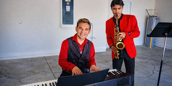Instructors perform at a Kissimmee real estate closing, showcasing piano and saxophone. 
