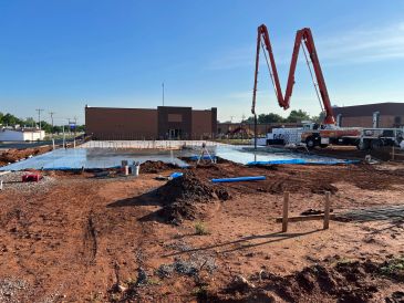 Construction site with concrete pump and foundation.