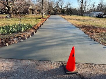 Freshly poured concrete driveway with an orange cone.
