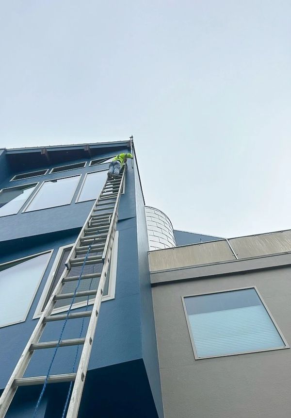 Worker painting commercial building. 