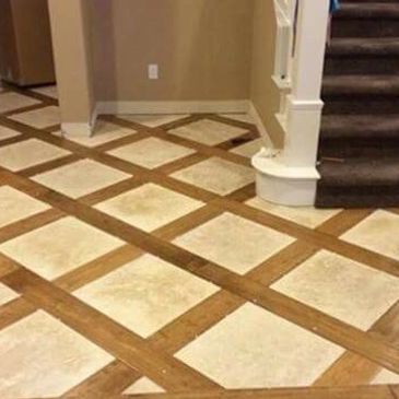 Floor with a checkered tile and wood pattern near stairs.