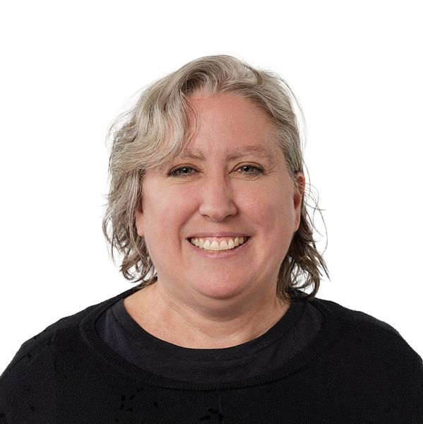 Smiling woman with gray hair and black sweater.