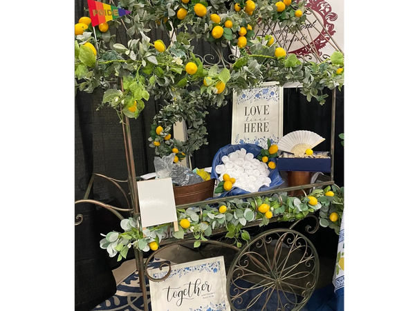 Cute metal cart decorated with lemons holding wash cloths and a "Love Lives Here" sign for drinks.