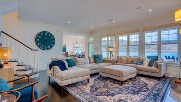 Cozy living room with large windows and blue accents.