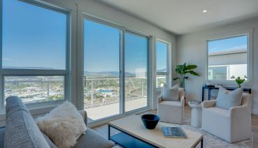 Bright living room with large windows and city views.