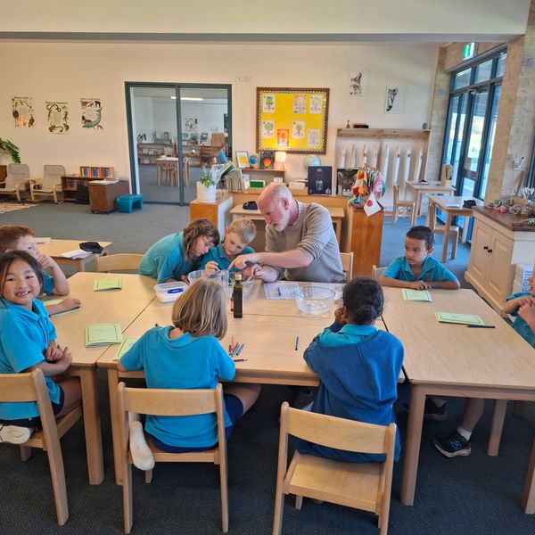Teacher engaging young students in a hands-on learning activity in a classroom.