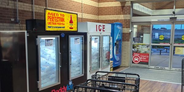 Ice storage units and a vending machine inside a store near the entrance.