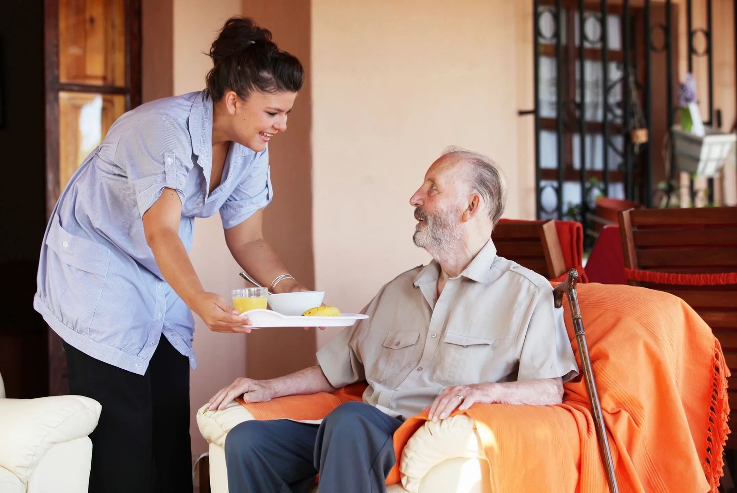 Compassionate caregiver providing in-home care during a healthy breakfast.