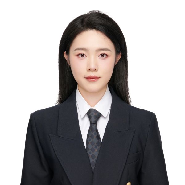 Professional woman in a black suit and tie, posing against white background.