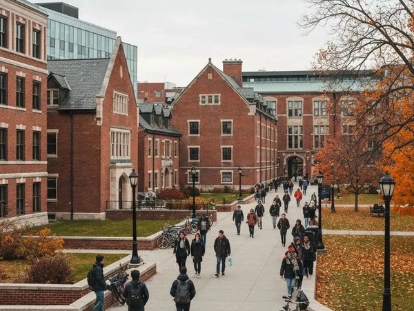 Students walking on a college campus during fall.