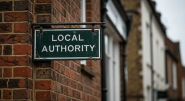 A green sign reading 'LOCAL AUTHORITY' attached to a brick wall.