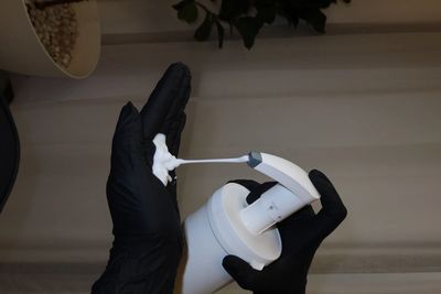 Foaming soap being dispensed onto a gloved hand.