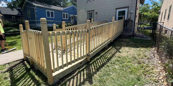 A newly constructed wooden wheelchair ramp attached to a house.