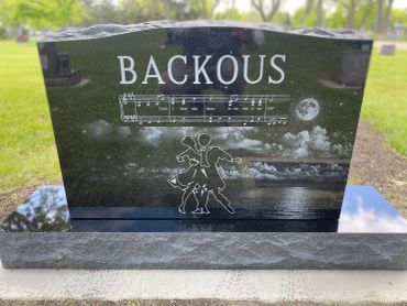 Engraved gravestone with a musical score and dancing couple.