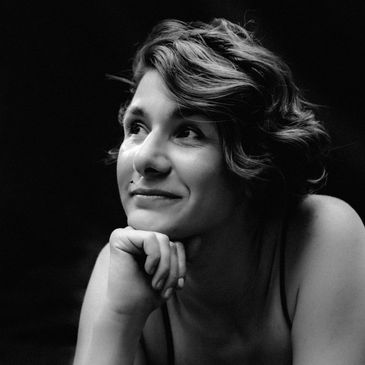 Black and white portrait of a smiling woman with short wavy hair.