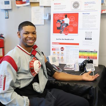 Man smiling while donating blood at a health clinic.