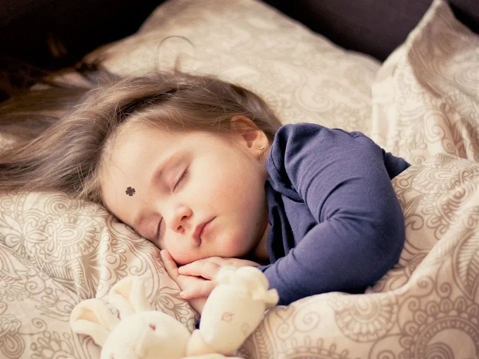  baby is sleeping soundly with a fever monitoring sticker indicateing NO FEVER, because it's still b
