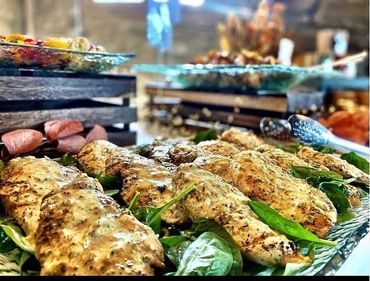 Herb-marinated grilled chicken on spinach, plated for Denver catering buffet service