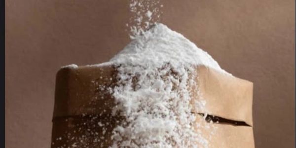 Powder falling onto a brown paper bag.