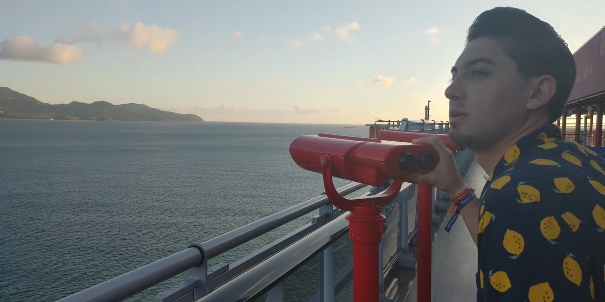 A curated travel flat-lay with a compass, passport, and cruise lanyard.