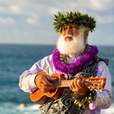 Hawaiian officiant with ukulele on Maui beach during wedding ceremony