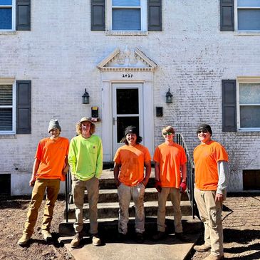 5 employees in front of a home. 