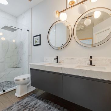 Renovated villa bathroom with floating dual sink vanity pebbled shower floor and rainfall showerhead