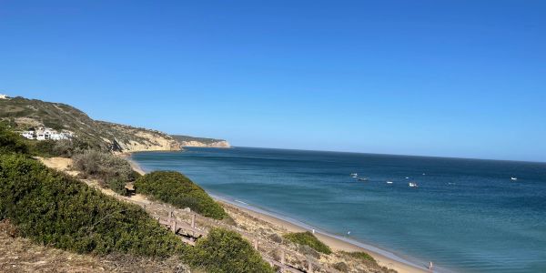Scenic coastal view with clear blue sky and calm ocean.